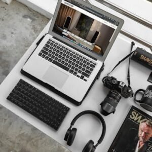 Overhead view of a modern workspace featuring a laptop, camera, and accessories.